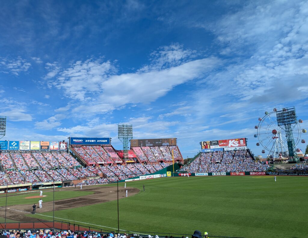 楽天モバイルパーク宮城の快晴の試合日。観覧車が見えるスタンドとグラウンドの様子