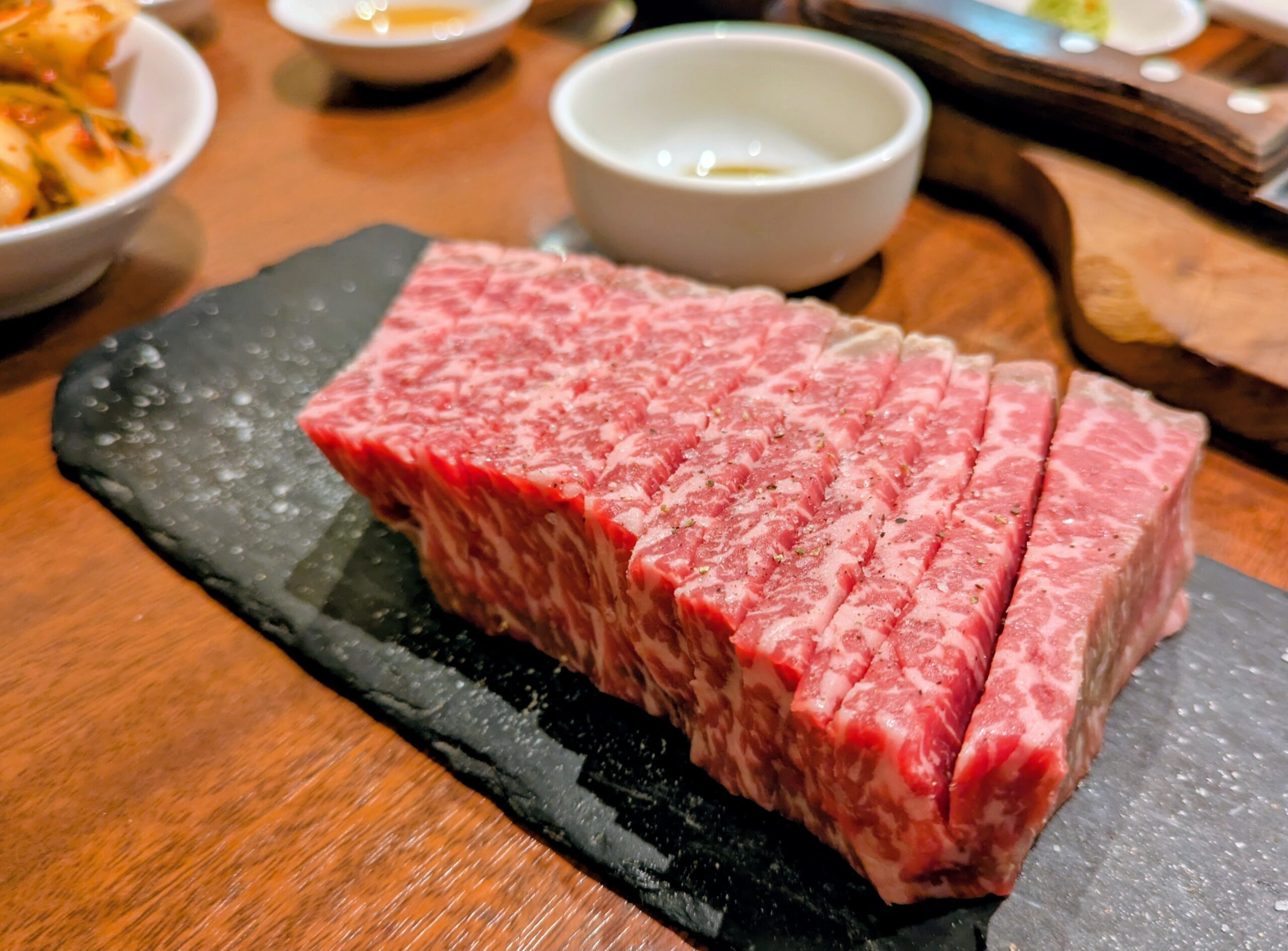 緒つじ名物・200g炭火炙りレンガ肉。好みの厚さに自分でカットしていただく贅沢な一皿