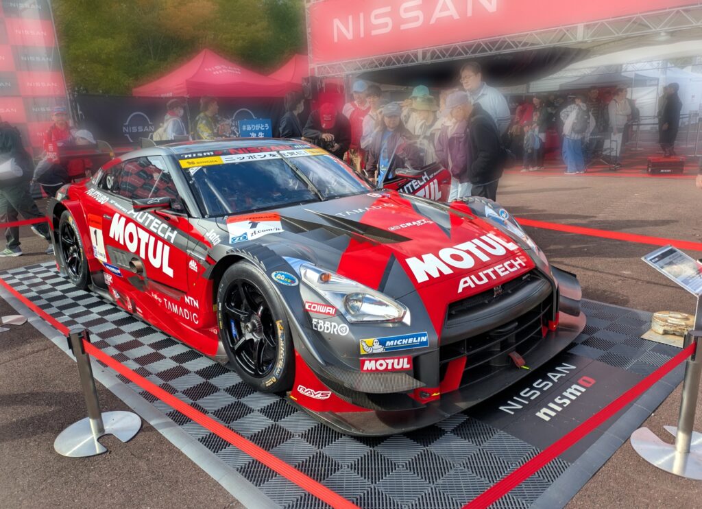 SUPER GTの展示エリアに並ぶNISSAN GTR。鮮やかな赤と黒のボディが印象的なGTマシン。